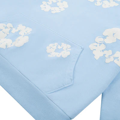 Denim Tears Cotton Wreath Sweatshirt in Powder Blue with puff-printed wreath design, soft cotton fabric, and relaxed fit for elevated streetwear style