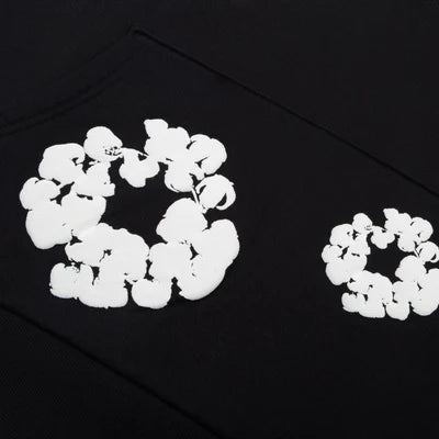 Denim Tears Cotton Wreath Sweatshirt in Black with puff-printed wreath design, soft cotton fabric, and relaxed fit for cultural and streetwear impact